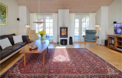 a living room with a couch and a table at Holiday Home Stubbegårdsparken Nakskov Vi in Knubbeløkke