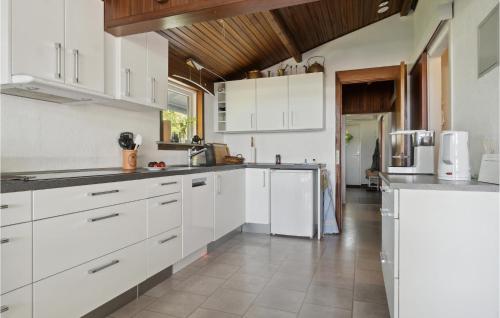 a kitchen with white cabinets and a tile floor at Beautiful Home In Vordingborg With Wifi in Vordingborg