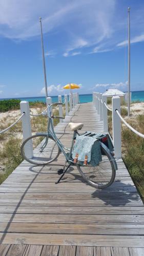 a bike parked on a wooden boardwalk on the beach at Alexandra Resort - All-Inclusive in Grace Bay