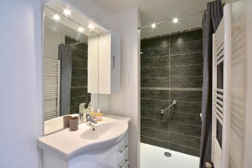 une salle de bain blanche avec un lavabo et une douche dans l'établissement La Halte Décinoise - Maison de avec jardin 103m2, à Vaulx-en-Velin