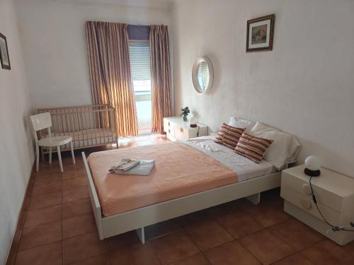 a bedroom with a large bed and a window at Apartamento Tiago in Sines