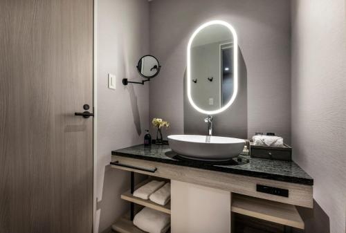 a bathroom with a sink and a mirror at Centara Grand Hotel Osaka in Osaka