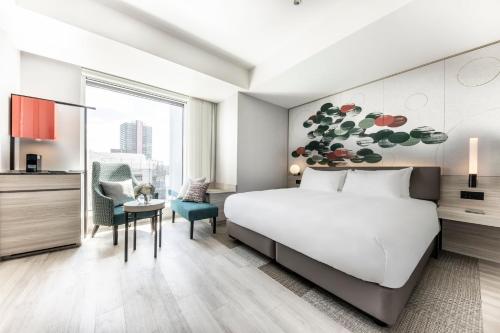 a hotel room with a bed and a desk and a chair at Centara Grand Hotel Osaka in Osaka