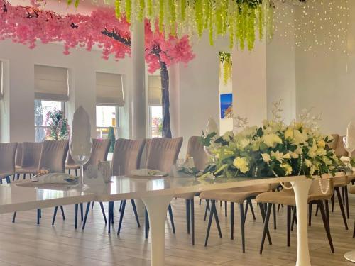 a dining room with a table with flowers and chairs at The Royal Hotel - Clacton On Sea in Clacton-on-Sea