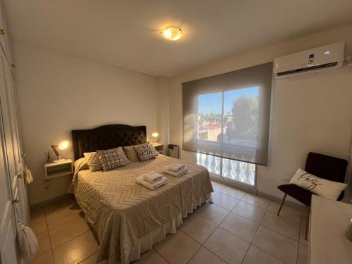 a bedroom with a bed and a large window at En el Corazón de la Quinta. in Villa Marini