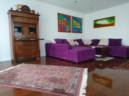 sala de estar con sofá púrpura y cómoda en Deluxe Apartment, en Überlingen