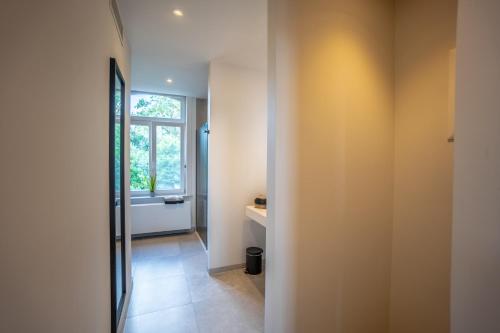 a hallway with a bathroom with a window at Burgemeesterhuys in Beringen