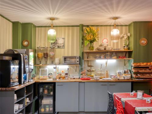 une cuisine aux murs verts et un comptoir avec de la nourriture dans l'établissement Hotel de Belfort, à Paris