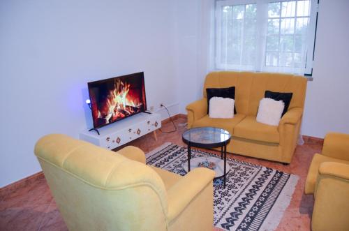 a living room with two chairs and a fireplace at Vivenda Carthagena, House Fundão in Fundão