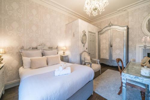 a bedroom with a large white bed and a table at Beautifully decorated, elegant apartment near town - Pass the Keys in Shrewsbury