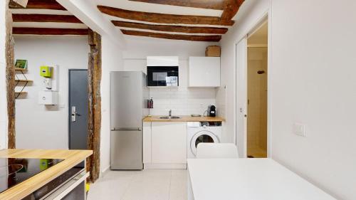 Il comprend une cuisine équipée d'un réfrigérateur et d'un lave-linge/sèche-linge. dans l'établissement 323 Suite Louis - Superbe Appartement à Paris, à Paris