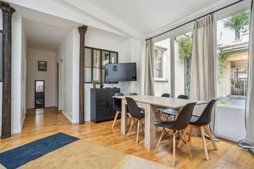 une salle à manger avec une table et des chaises dans l'établissement 205-Suite Villa Valmy, à Paris