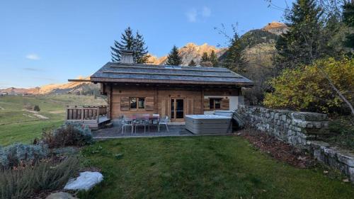 a log cabin with a table and chairs in a yard at SmartStay - Chalet Felix aux Confins in La Clusaz
