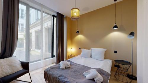une chambre avec un lit et une grande fenêtre dans l'établissement 140 Suite Ludo - Superbe Appartement à Paris, à Paris