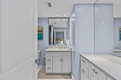 un bagno bianco con lavandino e specchio di Cozy 2br 2ba Retreat at Beachfront Resort, Heated Pool! a South Padre Island