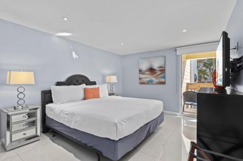 una camera da letto con un letto e una TV a schermo piatto di Cozy 2br 2ba Retreat at Beachfront Resort, Heated Pool! a South Padre Island