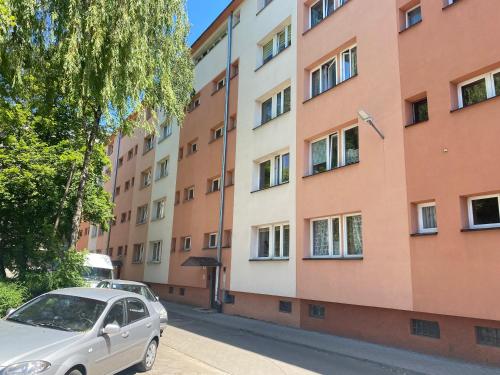 a silver car parked in front of a building at Apartament 3 SYPIALNIE, 3 BEDROOMS - Klimatyzacja - in Wrocław