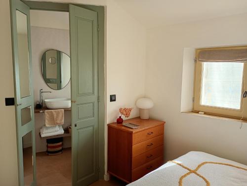 une chambre avec un lit, un lavabo et un miroir dans l'établissement Maison Jollion en Provence, à Boulbon