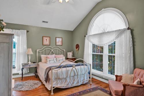 a bedroom with a bed and a large window at Hill House Bed and Breakfast in Loretto
