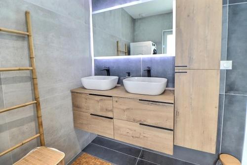 - une salle de bains avec deux lavabos sur un comptoir en bois dans l'établissement Alsace Colmar Appartement climatisée garage, parking et terrasse, à Colmar