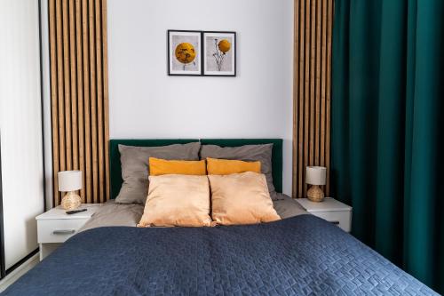 a bedroom with a blue bed with two night stands at Apart Paderewskiego in Bartoszyce