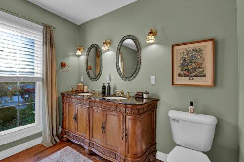 a bathroom with a sink and two mirrors on the wall at Hill House Bed and Breakfast in Loretto