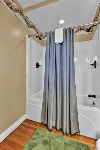 a bathroom with a tub and a shower curtain at Hill House Bed and Breakfast in Loretto