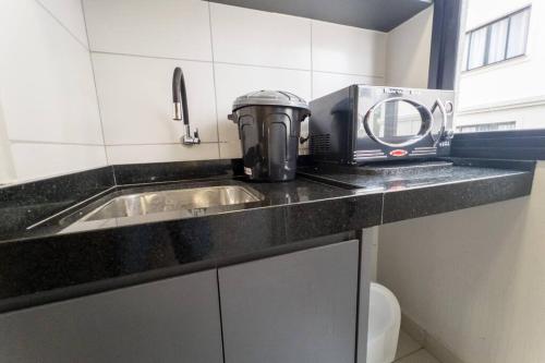 a kitchen counter with a toaster and a sink at Apartamento Smart Encantador in Maringá