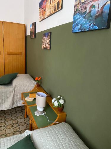 a room with two beds and a table with flowers on it at Green House Caldiero in Caldiero