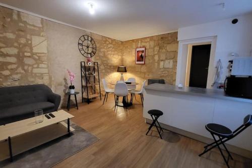 a living room with a couch and a table and chairs at Le QG in Saint-André-de-Cubzac