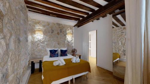 une chambre avec un lit et un mur en pierre dans l'établissement 200 Suite DDJ - Superbe Appartement à Paris, à Paris