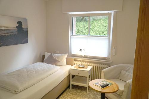 a small room with a bed and a chair and a window at Mansion in Bad Arolsen