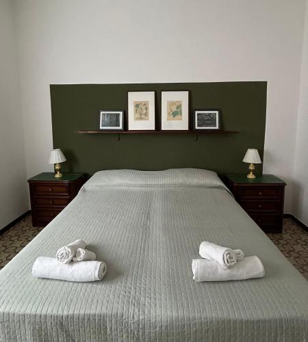 a bedroom with a large bed with towels on it at Green House Caldiero in Caldiero