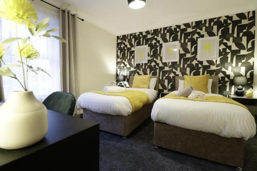 コルチェスターにあるStylish & Cosy Stay 2-Bed House Train Station Hospital Garden Fast WiFiの黒と白の壁のベッドルーム1室(ベッド2台付)