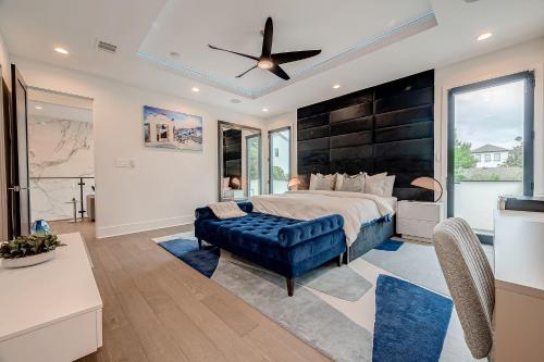 a bedroom with a large bed and a blue couch at Montrose Lux Pool Villa Houston in Houston