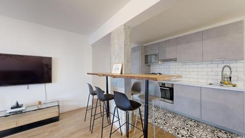 een keuken met een bar met krukken en een tv bij 199 Suite Monopoly - Superb Apartment in Paris in Parijs