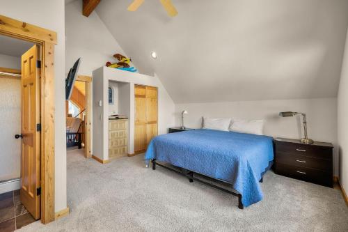 a bedroom with a bed with a blue comforter at Oregon Chalet in Redmond