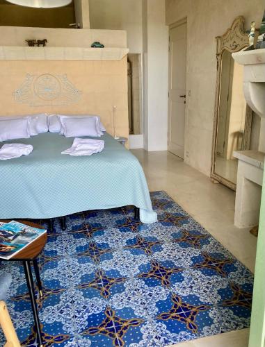 a bedroom with a bed and a blue rug at Boutique Hotel Masseria Sottomasi in Savelletri di Fasano