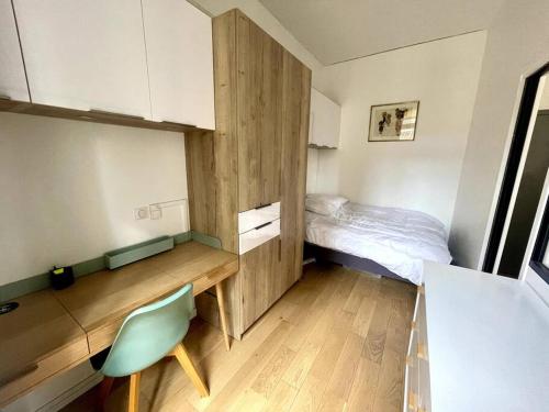 a small room with a bed and a desk at Charmant appartement avec balcon - Jardin Public in Bordeaux