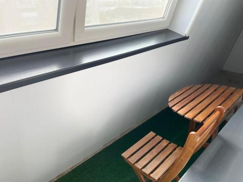 a wooden bench sitting under a window in a room at Family apartament in Oradea