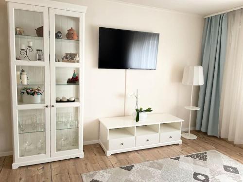 a living room with a white cabinet with a flat screen tv at Family apartament in Oradea