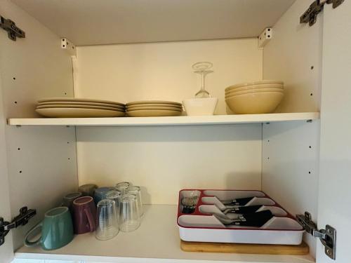 un garde-manger avec assiettes et vaisselle sur une étagère dans l'établissement Necker Paris, à Paris