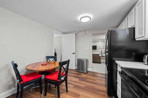 a kitchen with a table and chairs and a black refrigerator at Iola in Aurora