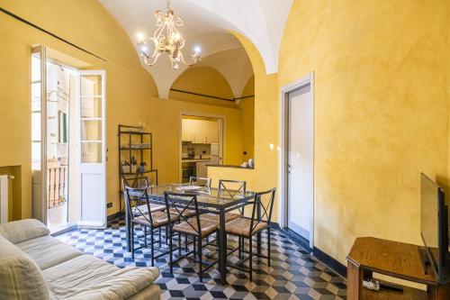 a dining room with a table and chairs and a couch at Case Schiaffino by Wonderful Italy in Laigueglia