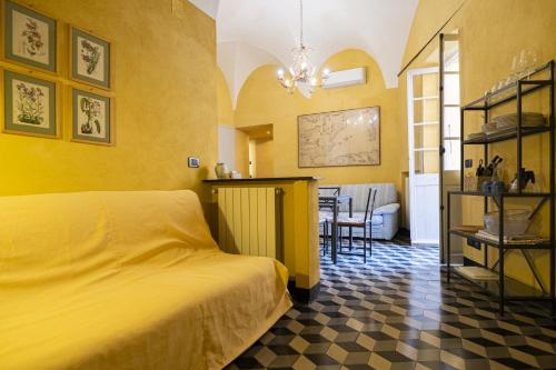 a yellow bedroom with a bed and a dining room at Case Schiaffino by Wonderful Italy in Laigueglia