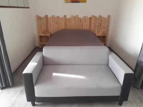 un letto in una camera con un divano bianco di Studio greoux les bains a Gréoux-les-Bains