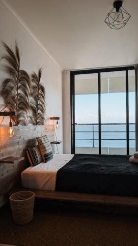 a bedroom with a large bed and a large window at Penthouse Ocean View Sesimbra - parking @center in Sesimbra