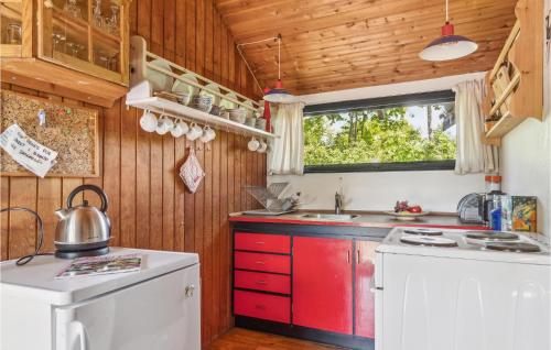 a kitchen with red and white cabinets and a window at Three-Bedroom Holiday Home In Nakskov in Nakskov