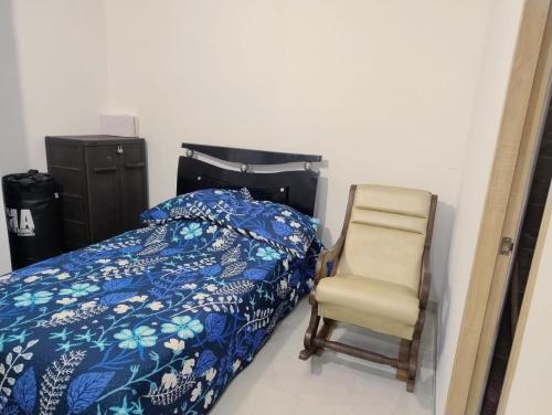 a bedroom with a bed and a chair at Condominio Bahía Solero Girardot in Ricaurte