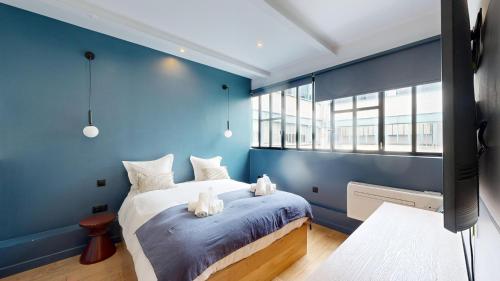 une chambre bleue avec un lit avec des animaux en peluche dessus dans l'établissement 178 Suite Cesar - Superb apartment in Paris, à Paris